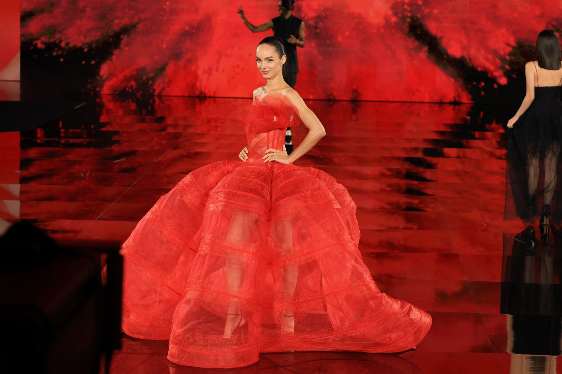 La modelo Luma Grothe brilló con un voluminoso vestido rojo, que combinó con una coleta pulida y labios rojos. 