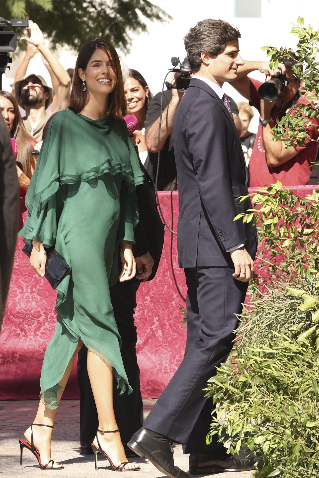 Sofía Palazuelo eligió un vestido vaporoso confeccionado a capas escalonadas de chiffon de seda mate y cortado al bies, firmado por Garaizabal Studio.  La mujer de Fernando Fitz-James Stuart combinó el diseño verde botella con sandalias altas y bolso tipo clutch en color negro. Al contrario que otras invitadas, no lució tocado, y optó por un beauty look sencillo, con melena suelta y maquillaje en tonos naturales. 