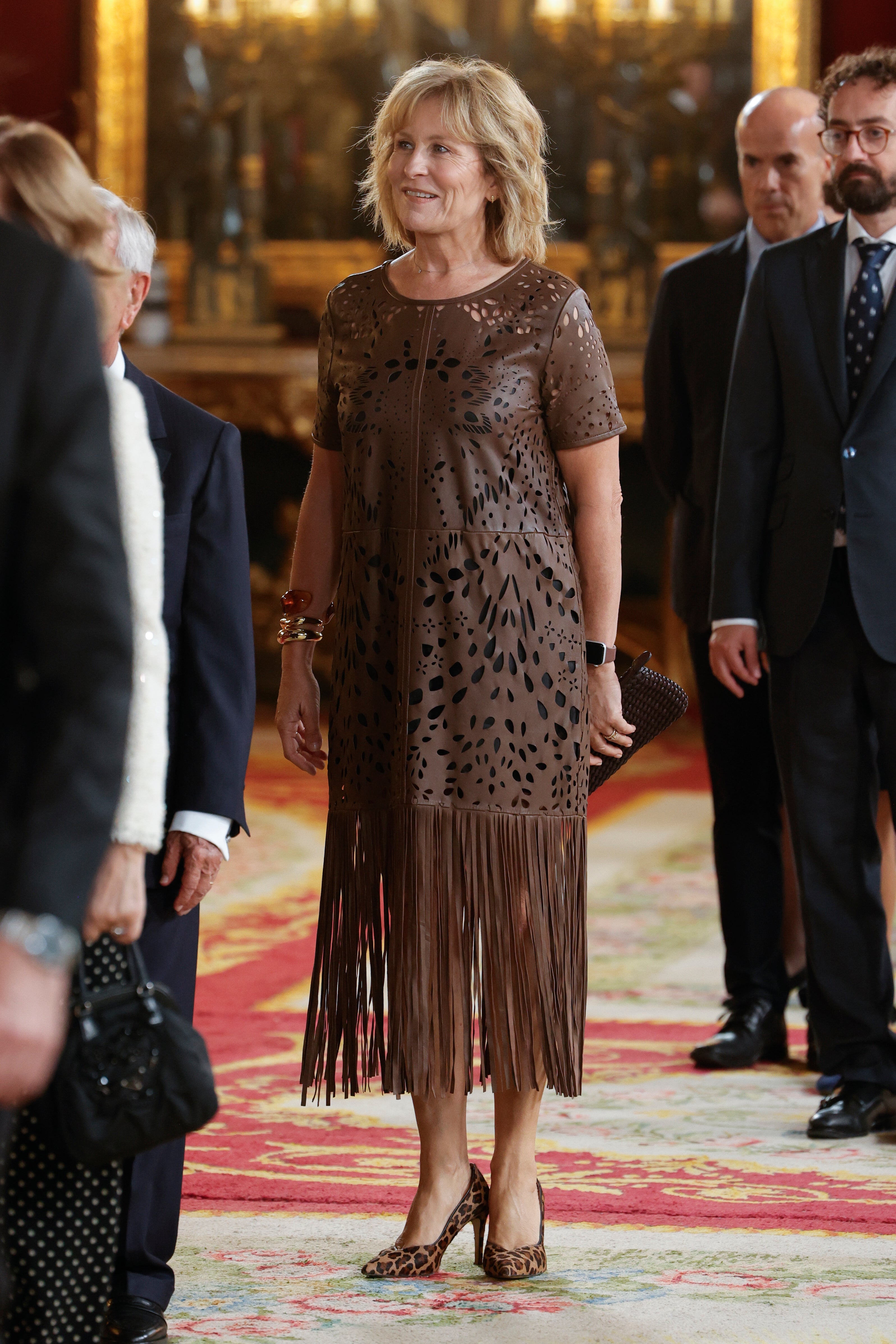 María Rey con vestido de piel troquelada con bajo de flecos en color marrón. 