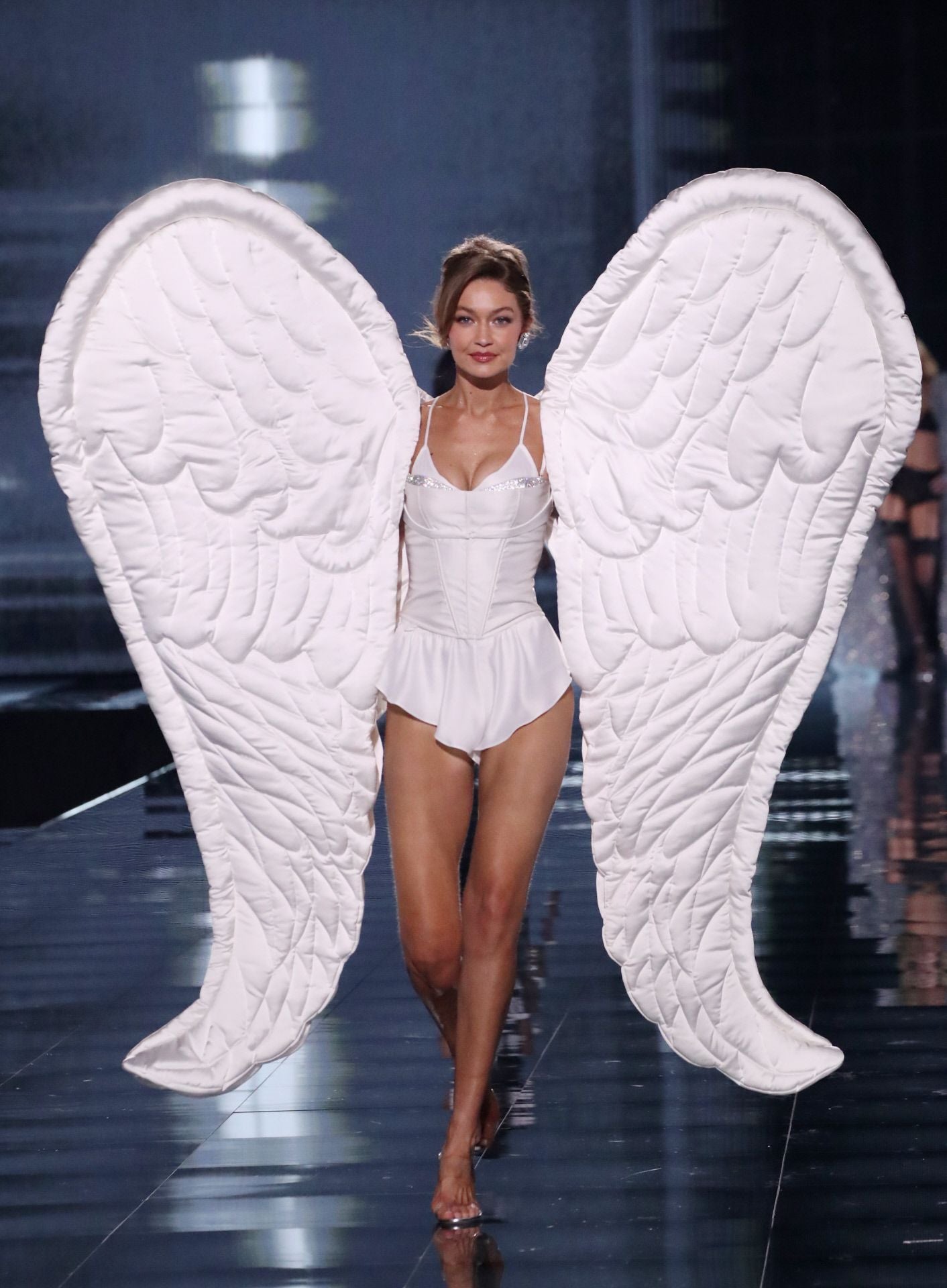 Bella Hadid con un body en color blanco y las tradicionales alas de ángel. 