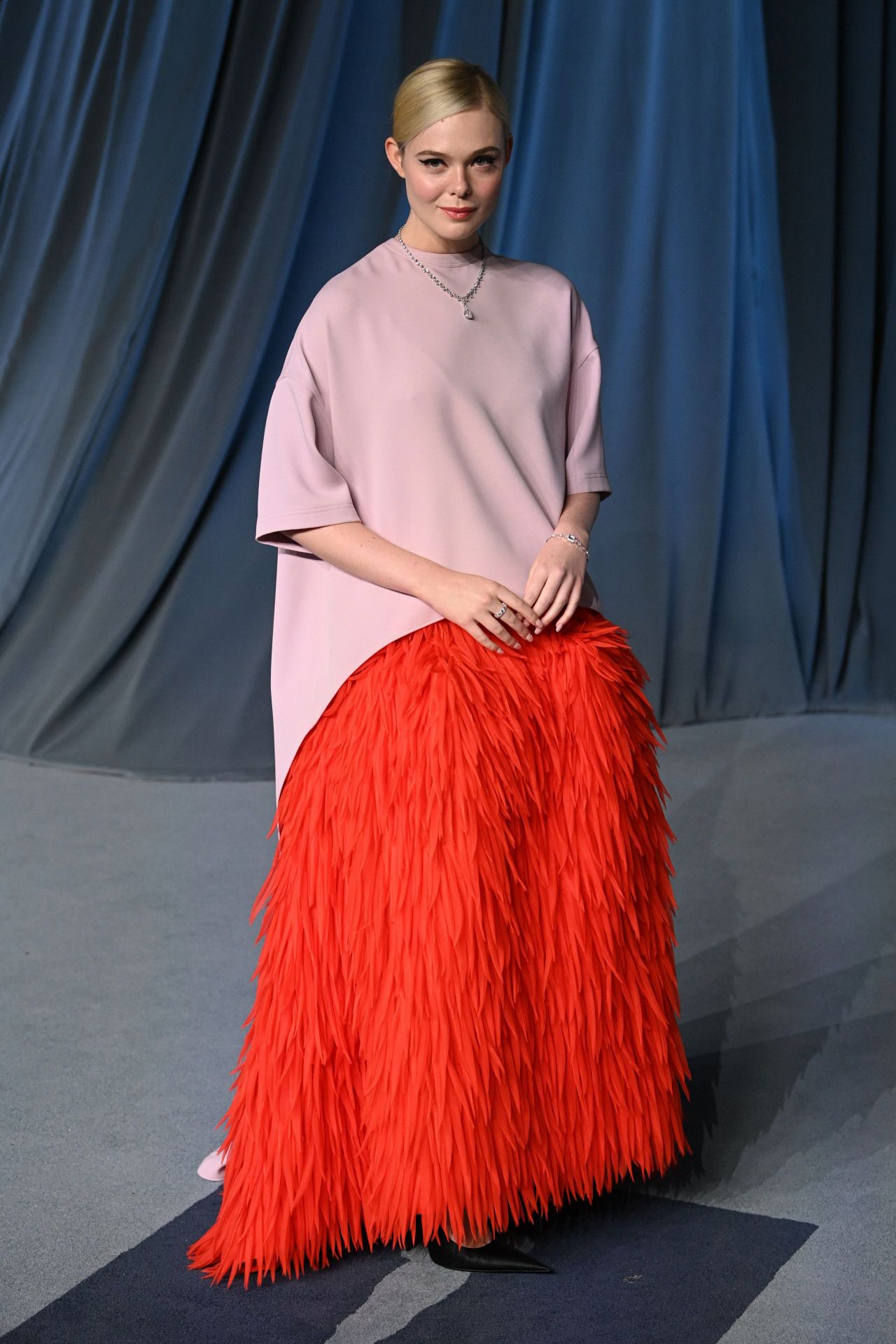 Elle Fanning escogió un diseño de Balenciaga firmado por Pierpaolo Piccioli, que combinaba una falda confeccionada con plumas en color rojo y un cuerpo en rosa.