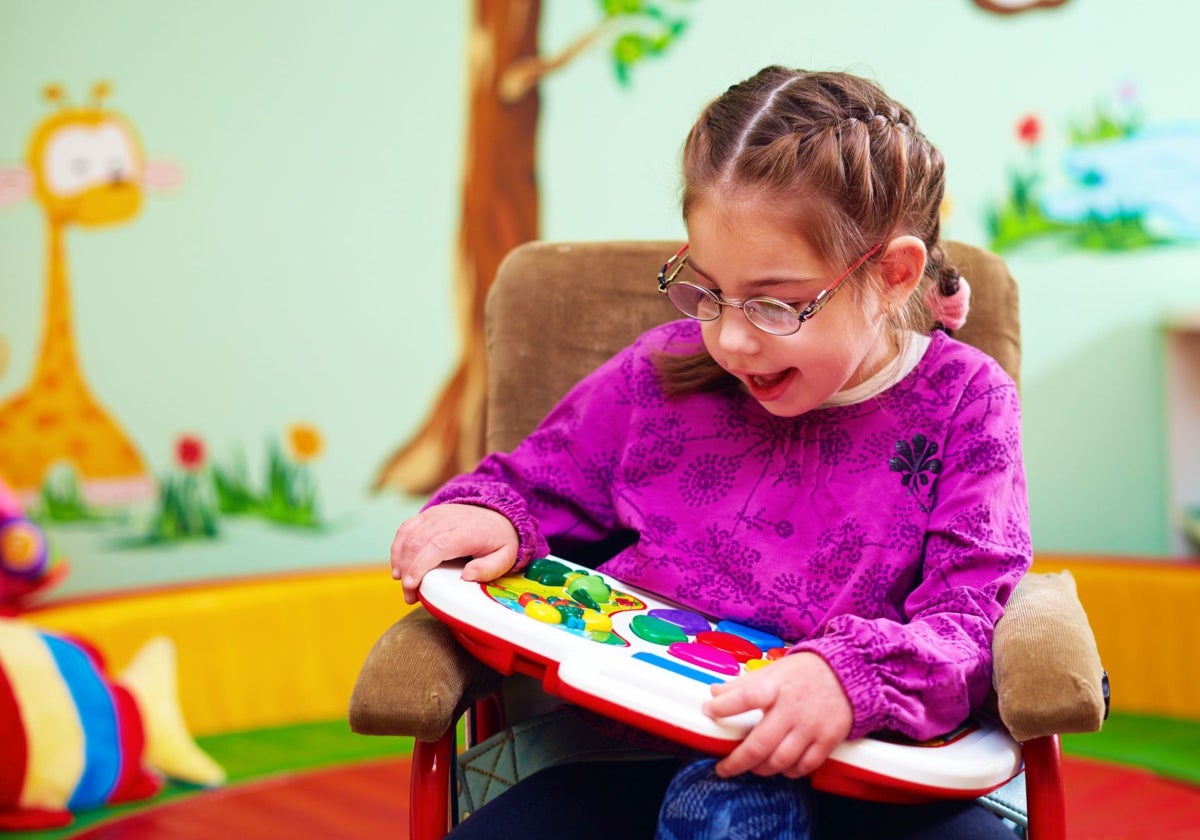 Una niña con discapacidad intelectual, con su juguete