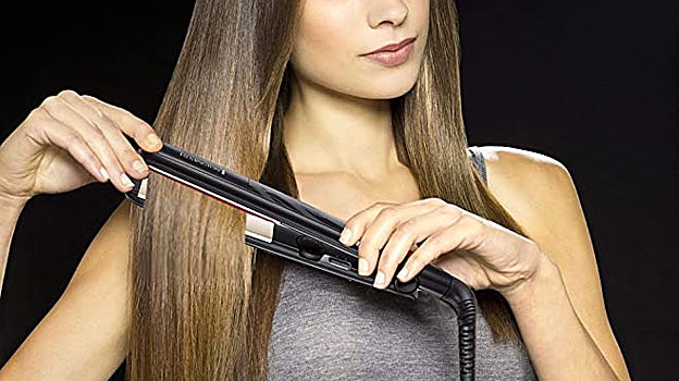 Mujer alisándose el cabello