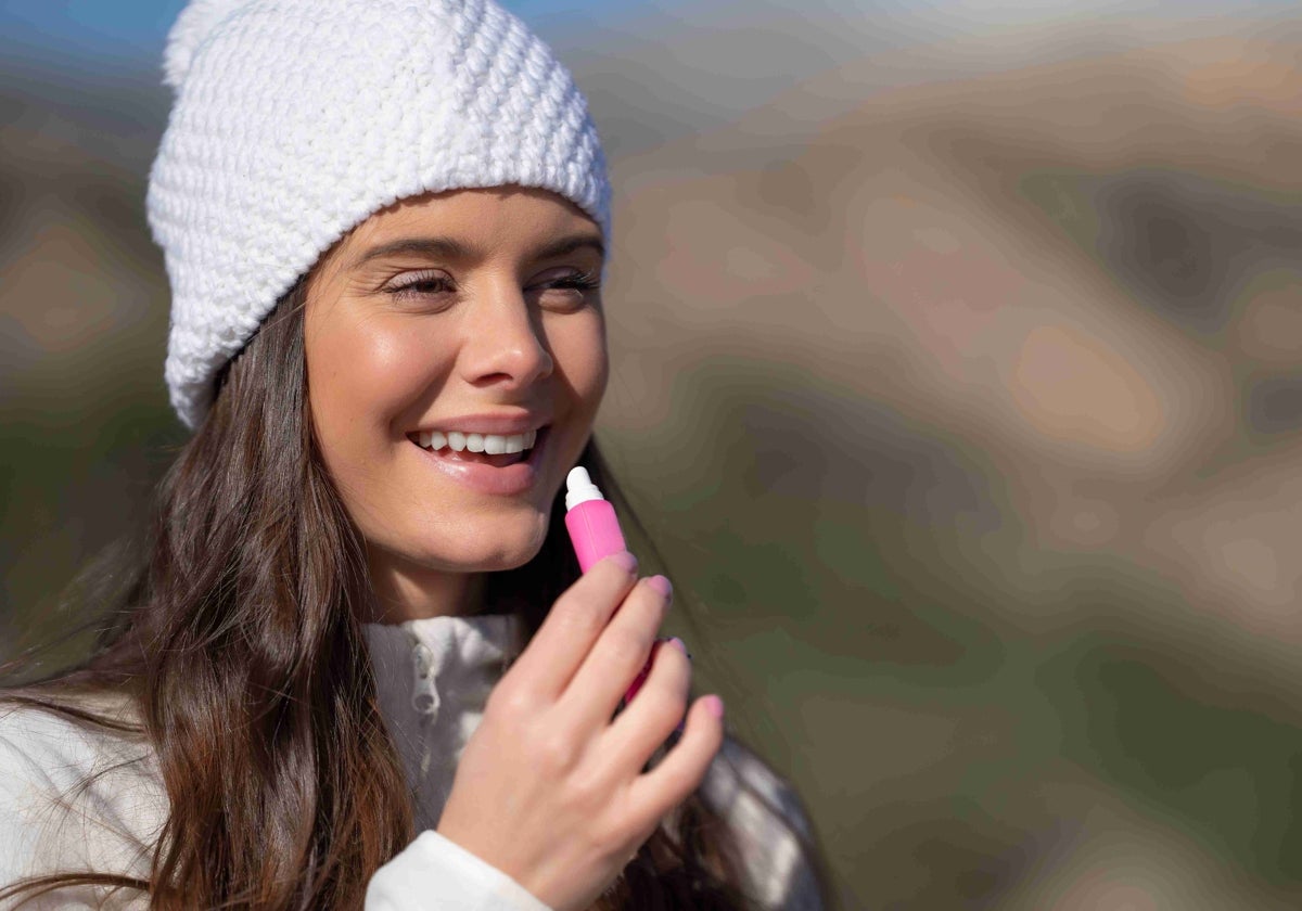 Una mujer se aplica un stick labial en la montaña