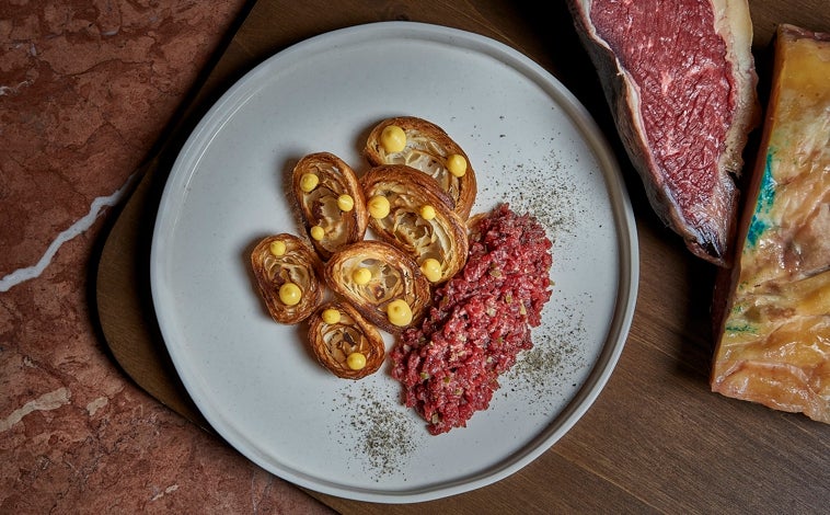 Imagen principal - Arriba, el steak tart del chef Mario Sánchez. Abajo, otro de sus platos, en los que reina el producto y se luce el alma francesa en las salsas y técnicas. Al lado, el cocinero gaditano con su mujer, la jefa de sala y experta en vinos francesa Charlotte Finkel.