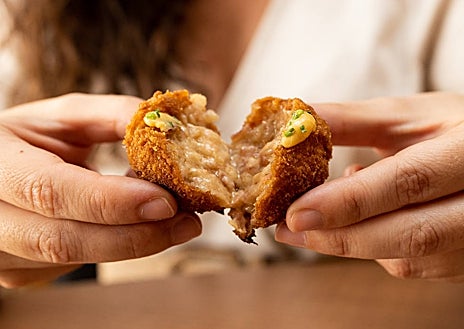 Imagen secundaria 1 - Arriba, guiso de callos con huevo frito en La Barra de la Reme. Abajo, su croqueta de pote gallego y las 'bravas muy bravas' que sirve este nuevo espacio del barrio de Salamanca