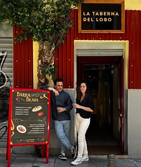 Imagen secundaria 2 - Sobre estas líneas, arriba, las patatas bravas. Abajo, a la izquierda, la ensaladilla 'golpeá' de gambón. A la derecha, Daniel Montes y Ana Romero, en la puerta de La Taberna del Lobo de Malasaña