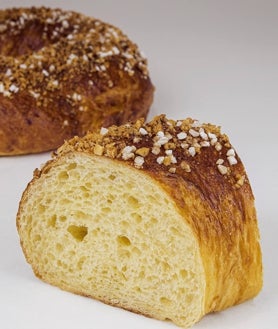 Imagen secundaria 2 - Sobre estas líneas, arriba, roscón clásico relleno de nata de La Mallorquina. Abajo, a la izquierda, formado de roscones en el obrador de Mallorca. A la derecha, roscón de Umikobake