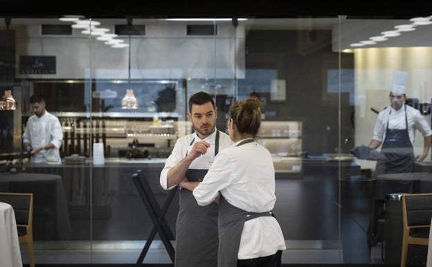 El chef comenta con una miembro de su equipo los detalles del próximo servicio