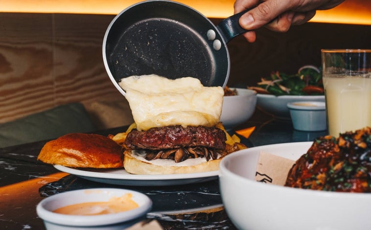 Imagen principal - Sobre estas líneas, la hamburguesa 'Heidi Love' servida a modo de raclette. Abajo, los nachos de La Carnaza y Miguel Crespo, fundador del proyecto