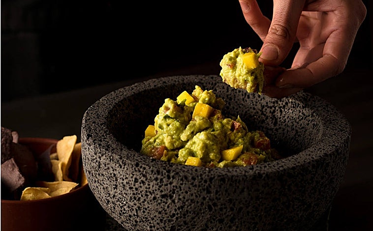 Imagen principal - El guacamole de Cabrón, que sirve con una serie de salsas, mango troceado y nachos; su decoración y su cóctel Sotol Sour. 