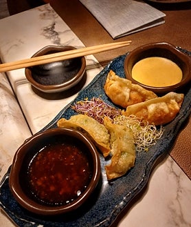 Imagen secundaria 2 - Sobre estas líneas, arriba, los baos artesanos de atún rojo salvaje y de secreto ibérico. Abajo, a la izquierda, los maki de atún picante. A la derecha, las gyozas.