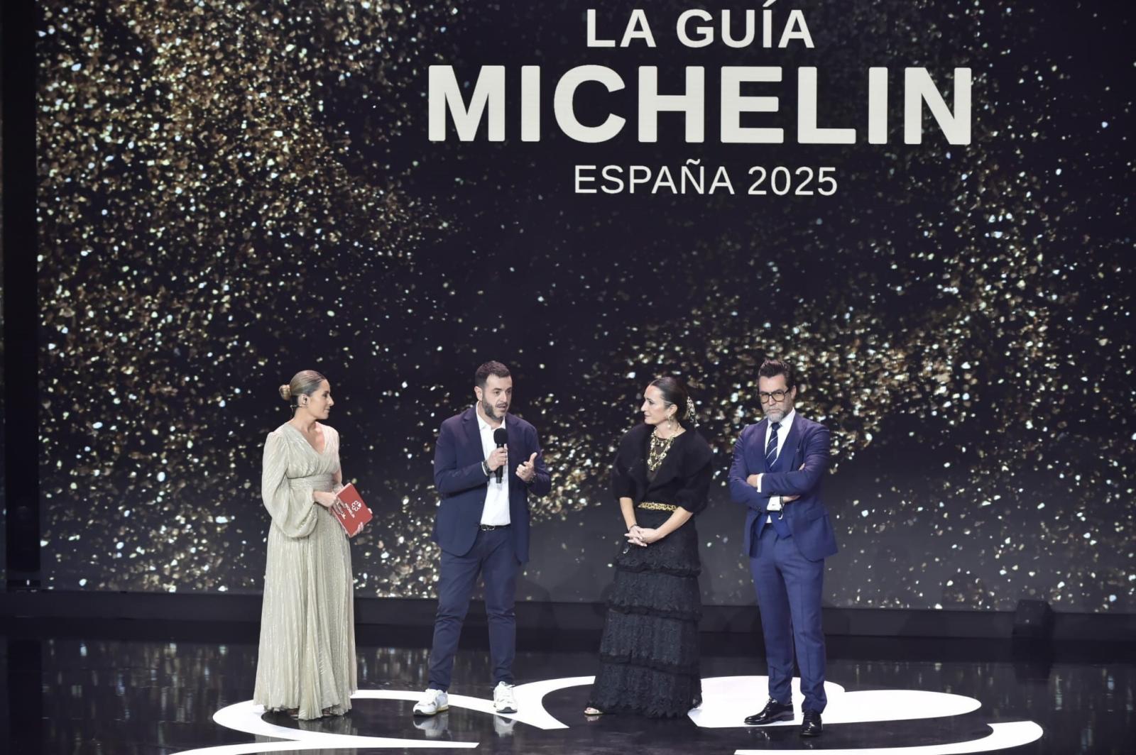 La periodista, Ainhoa Arbizu (i), la cocinera y exconcursante de MasterChef, María Morales (2d) y el chef Quique Dacosta (1d), durante la gala de la Guía Michelin 2025, en el Auditorio y Centro de Congresos Víctor Villegas