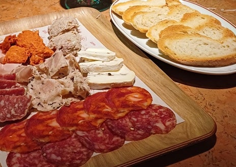 Imagen secundaria 1 - Sobre estas líneas, chipirones en su tinta, la tabla de charcutería y quesos y el carpaccio de vaca con parmesano y aceite picante de Martín Tostón