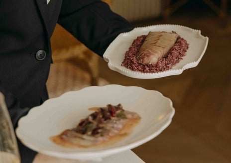 Imagen secundaria 1 - La terraza en el jardín de El Patio de Claudio, su plato de corvina curada en sal marinada con cerezas y el chef Mario Vallés.