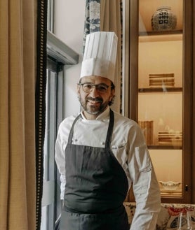 Imagen secundaria 2 - La terraza en el jardín de El Patio de Claudio, su plato de corvina curada en sal marinada con cerezas y el chef Mario Vallés.