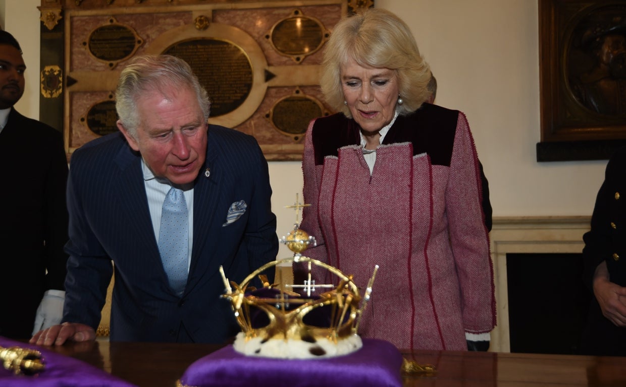 Carlos de Inglaterra y Camila observan una corona