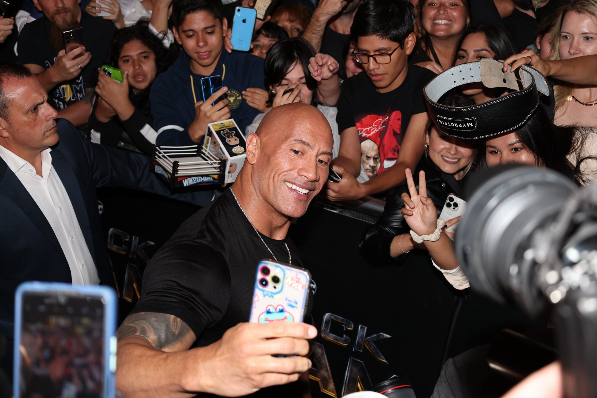 El actor Dwayne Johnson durante el photocall de la premier Black Adam haciéndose fotos con sus fans