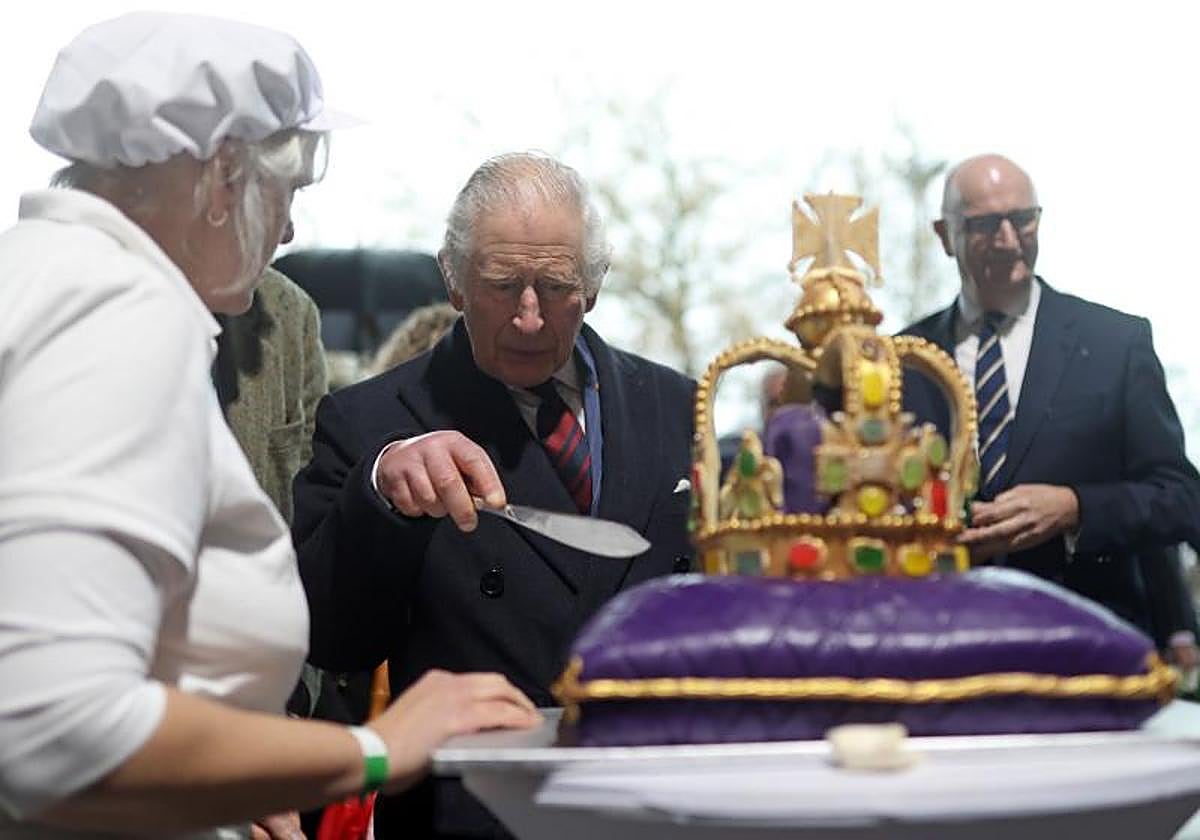 El Rey Carlos III corta una tarta en forma de corona durante su visita a Berlín