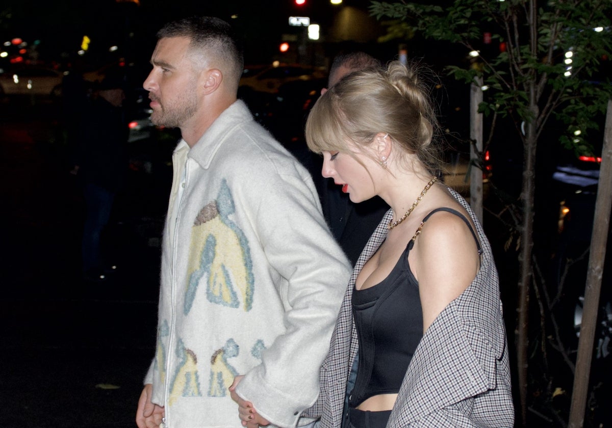 Travis Kelce y Taylor Swift saliendo de un restaurante