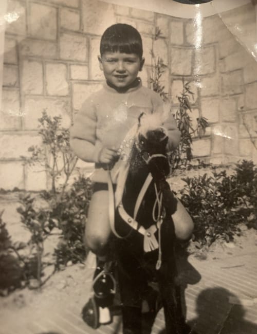 El periodista Juan Ramón Lucas de niño subido a un caballo de juguete