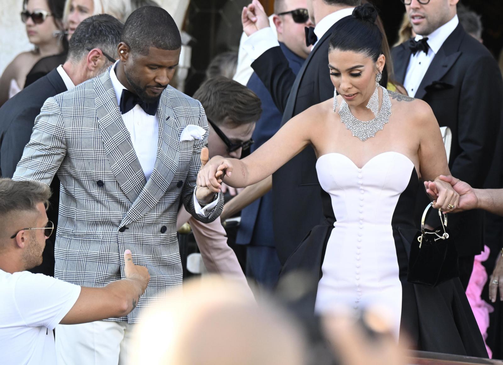 El músico estadounidense Usher  y su esposa Jenn Goicoechea salen de un hotel en Venecia, en el segundo día de las celebraciones de la boda del fundador de Amazon, Jeff Bezos.