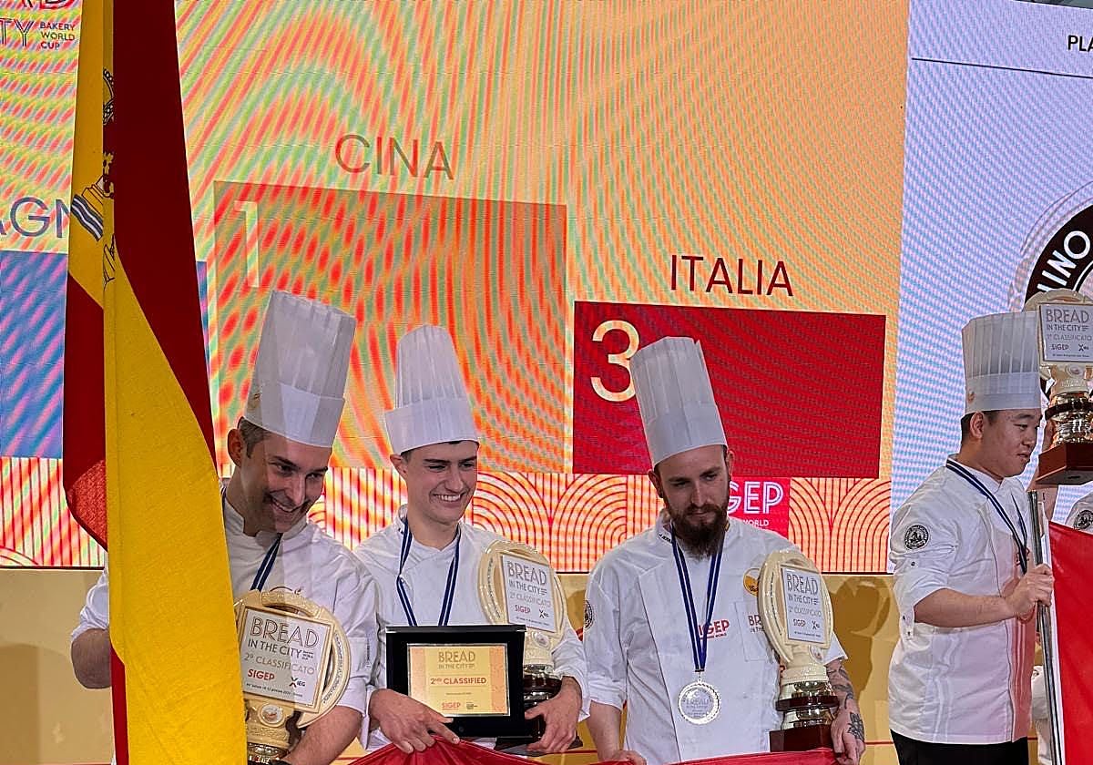 José Roldán, a la izquierda, con su equipo, en el podium