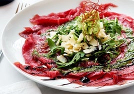 Tostada de carpaccio, hummus de remolacha, rúcula y brotes de soja