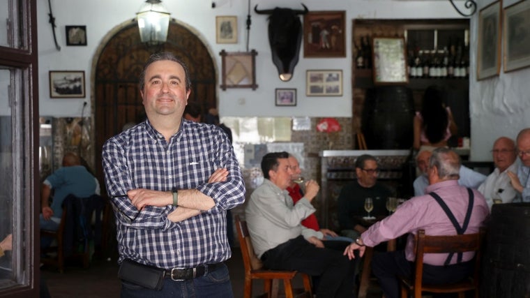 Rafael Guzmán posa en la bodega, delante de un grupo de clientes
