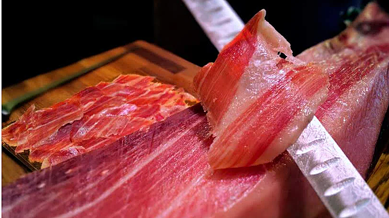 El jamón se corta a cuchillo y al momento delante del cliente