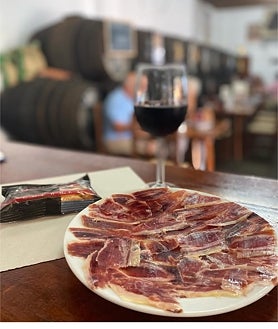 Imagen secundaria 2 - Potaje de garbanzos, salón interior con los barriles y plato de jamón ibérico de la bodega Pepe Girón, en Bormujos