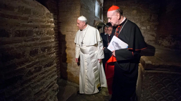 Fotografía facilitada por el diario 'L'Osservatore Romano', en 2013, con el Papa Francisco (izquierda), junto al cardenal Angelo Comastri, durante una visita no programada del Pontífice a las excavaciones de la necrópolis vaticana, donde rezó ante la tumba de San Pedro