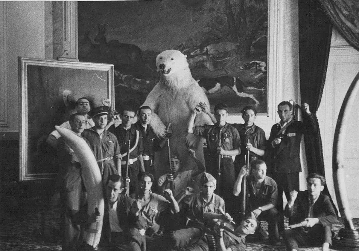 Un grupo de milicianos posa junto a los objetos y obras de arte incautados en el Palacio de Liria durante la guerra