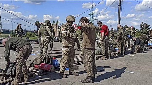 Militares rusos cacheando a militares ucranianos evacuados de la planta siderúrgica sitiada de Azovstal en Mariupol