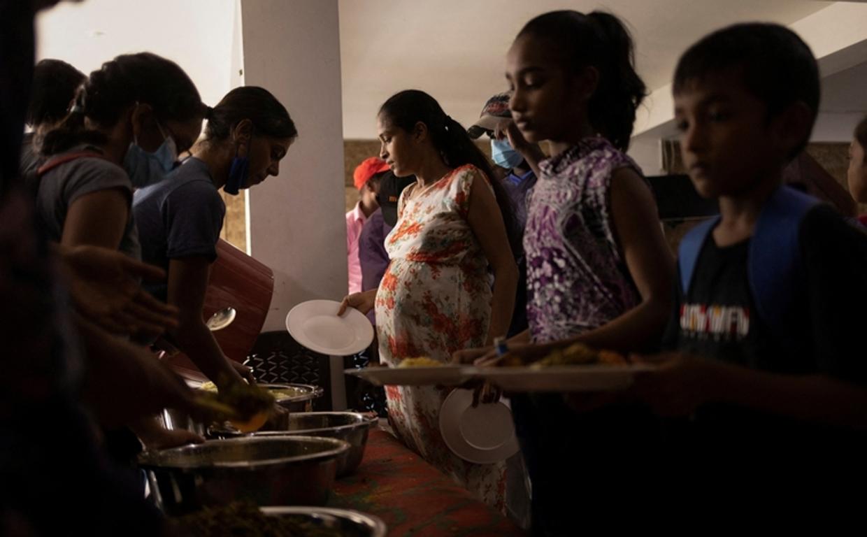 Voluntarios reparten alimentos a la población en una iglesia de Colombo