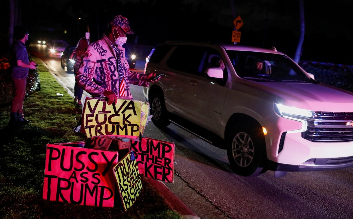 Un hombre con pancartas cerca de la residencia de Trump en Florida