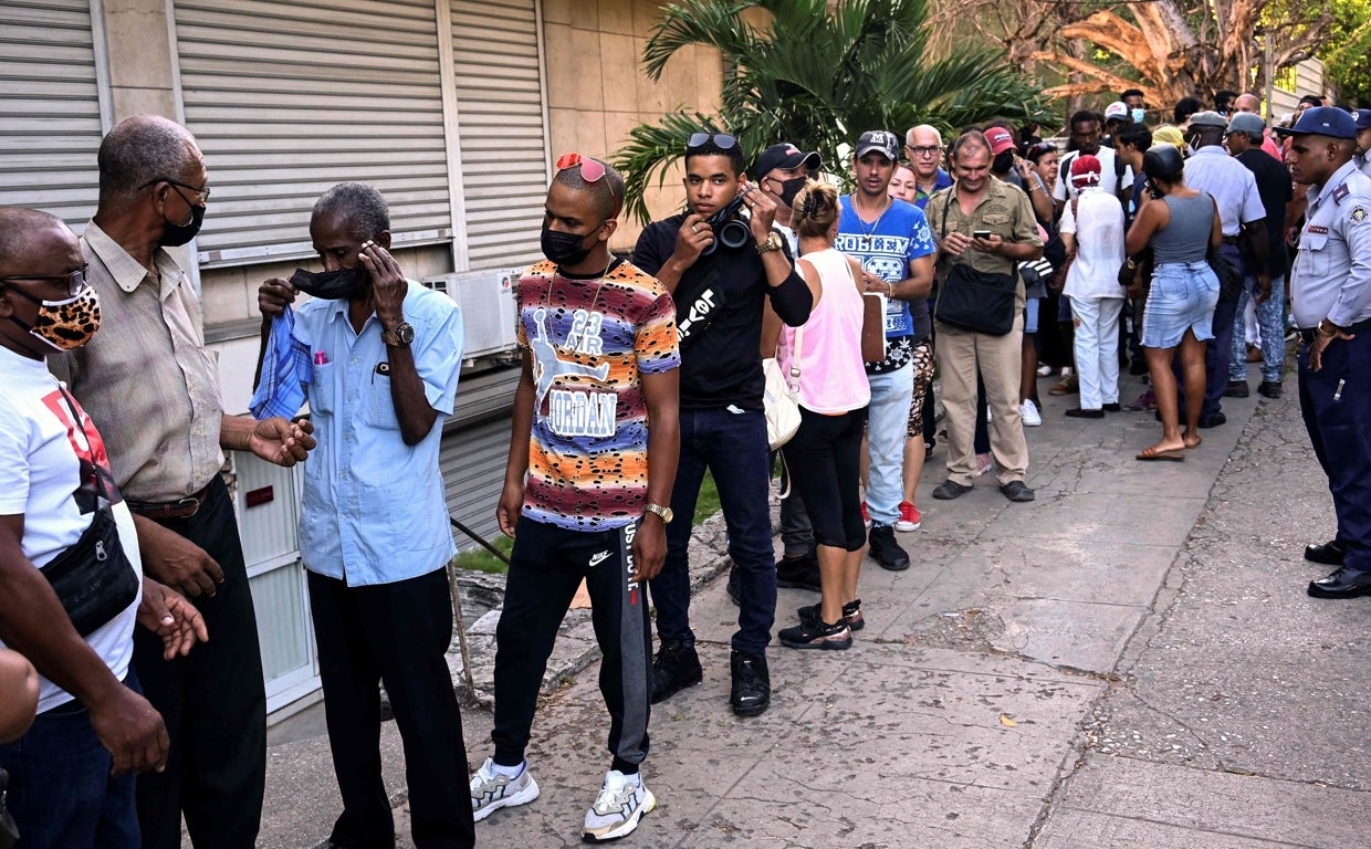 Un grupo de personas hace cola frente a una oficina de cambio en La Habana