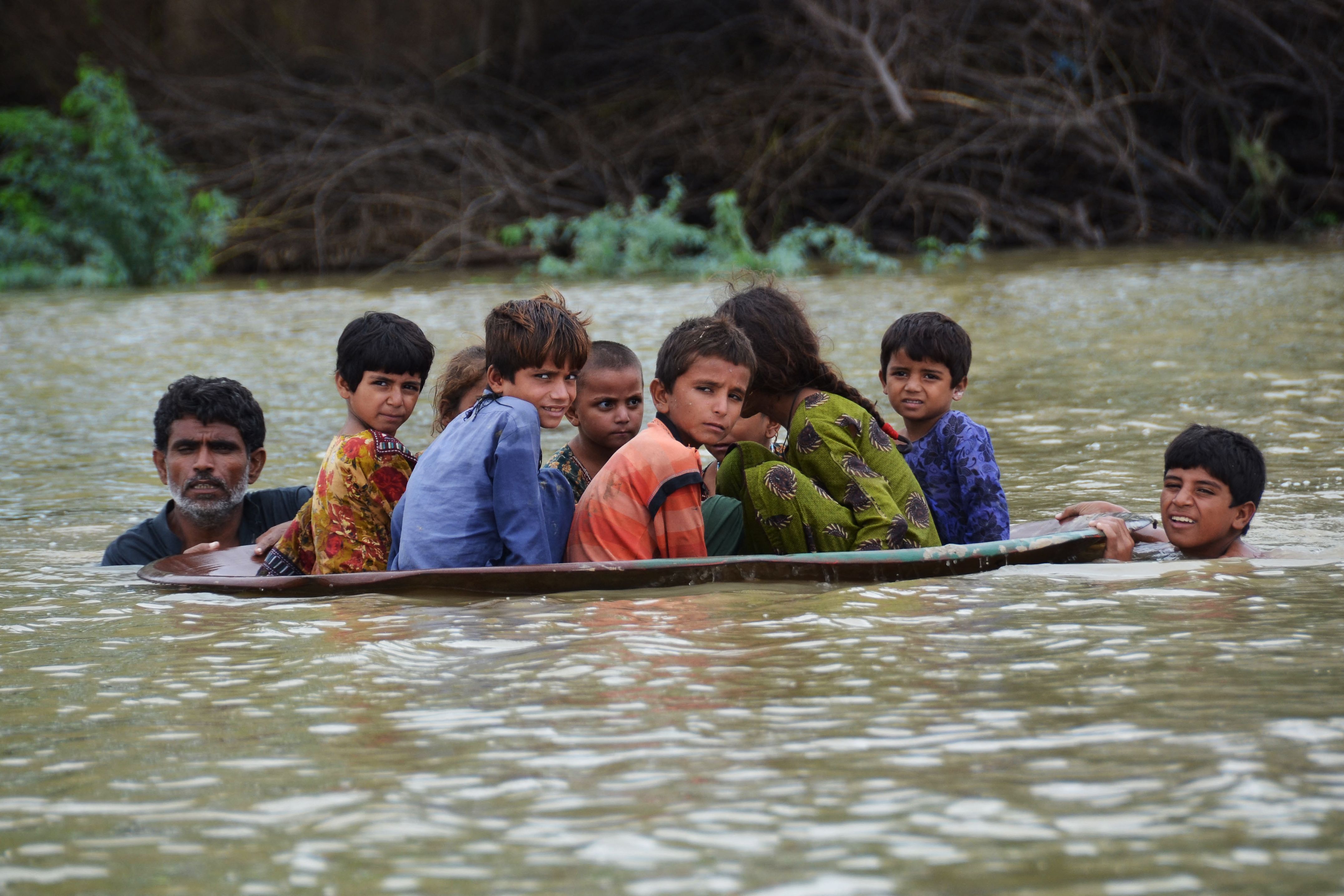 Un hombre impulsa a un grupo de niños en la provincia de Balochistán.