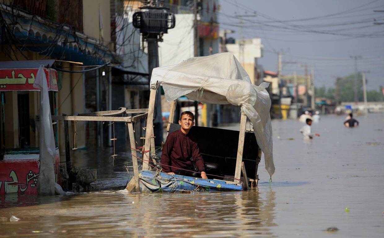 Un joven pakistaní improvisa una balsa para navegar por la ciudad de Nowshera