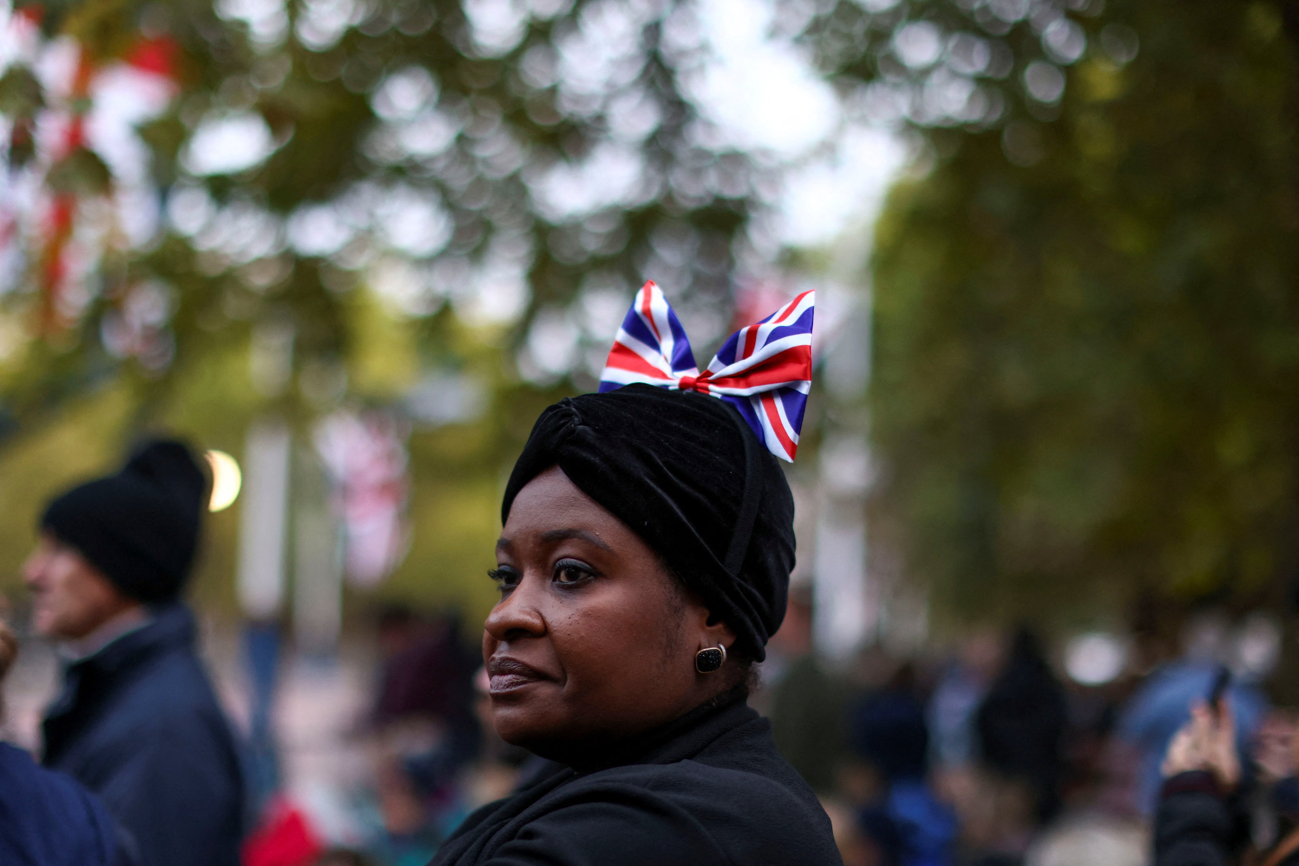 Una mujer espera el paso de la procesión fúnebre para despedir a la Reina Isabel II. 