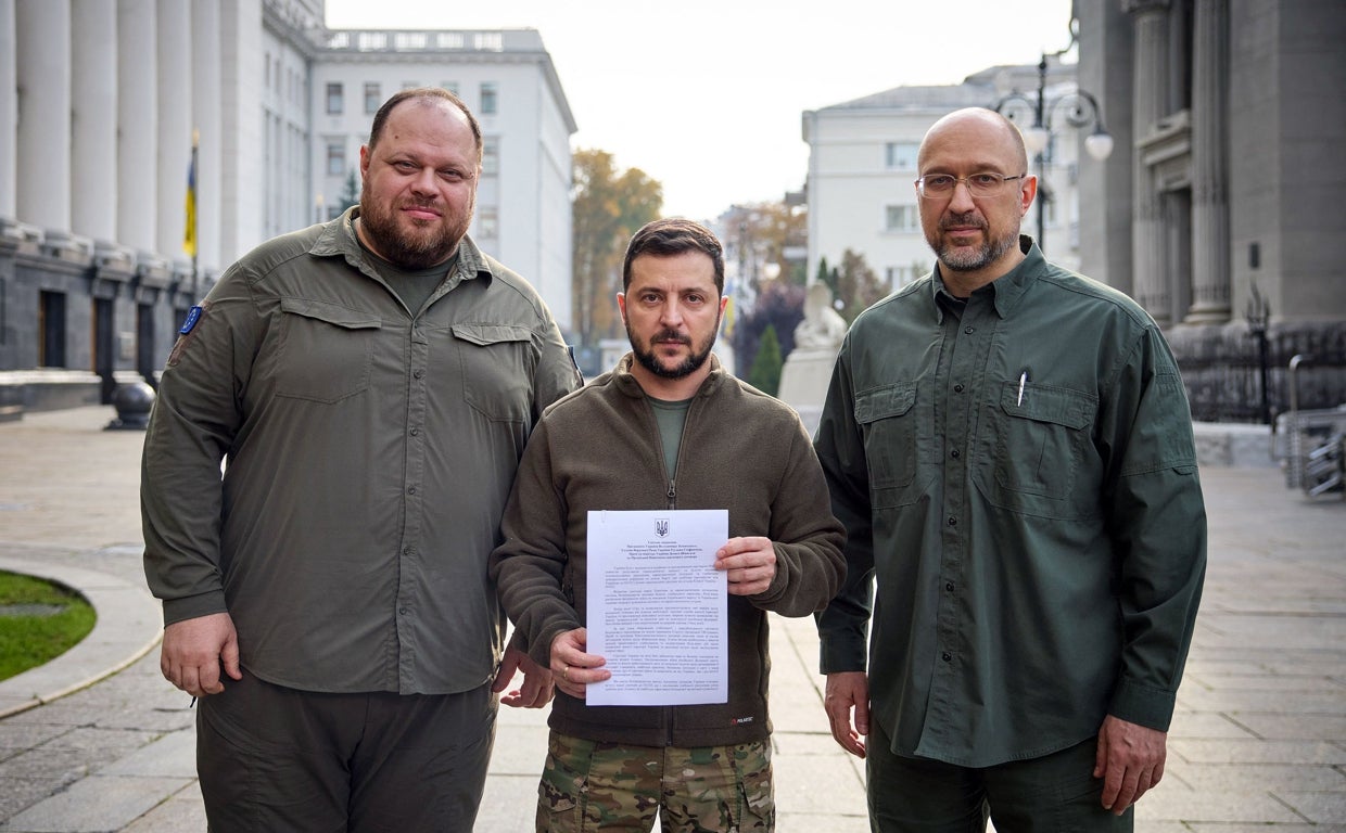 El presidente ucraniano VolodÍmIr ZelenskI (C), el primer ministro ucraniano Denys Shmyhal (R) y el presidente del Parlamento ucraniano Ruslan Stefanchuk (L) posando con el documento de solicitud de adhesión rápida a la OTAN