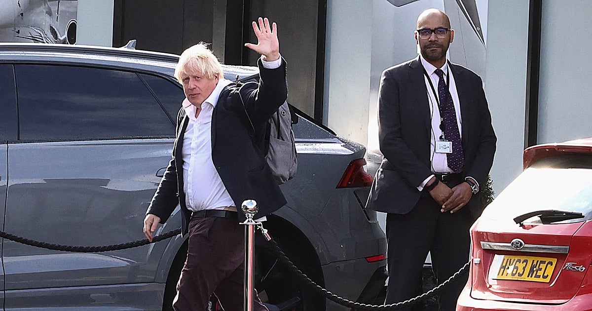 Johnson saluda a los fotógrafos que recogen su llegada a Londres