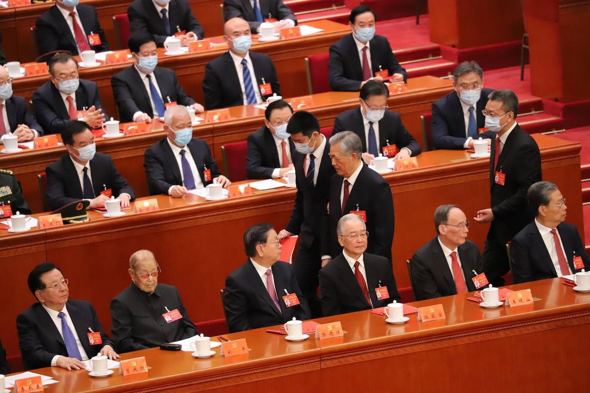 Cabizbajo, Hu Jintao pasa ante sus antiguos camaradas, entre ellos quien fuera su primer ministro, Wen Jiabao, que ni siquiera le mira.