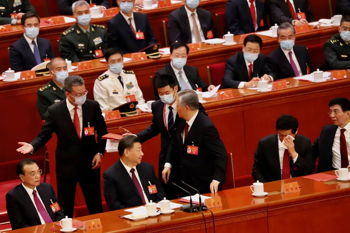 Mientras el ayudante de Xi y el bedel le insisten indicándole la salida, el número tres, Li Zhanshu, se seca el sudor azorado y Wang Huning mira con la boca abierta.