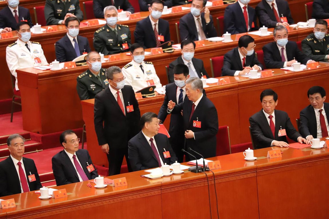 Durante más de un minuto, Hu Jintao sigue discutiendo con el ayudante de Xi Jinping y el bedel para no salir de la reunión. Intenta zafarse del bedel, que le sujeta el brazo.