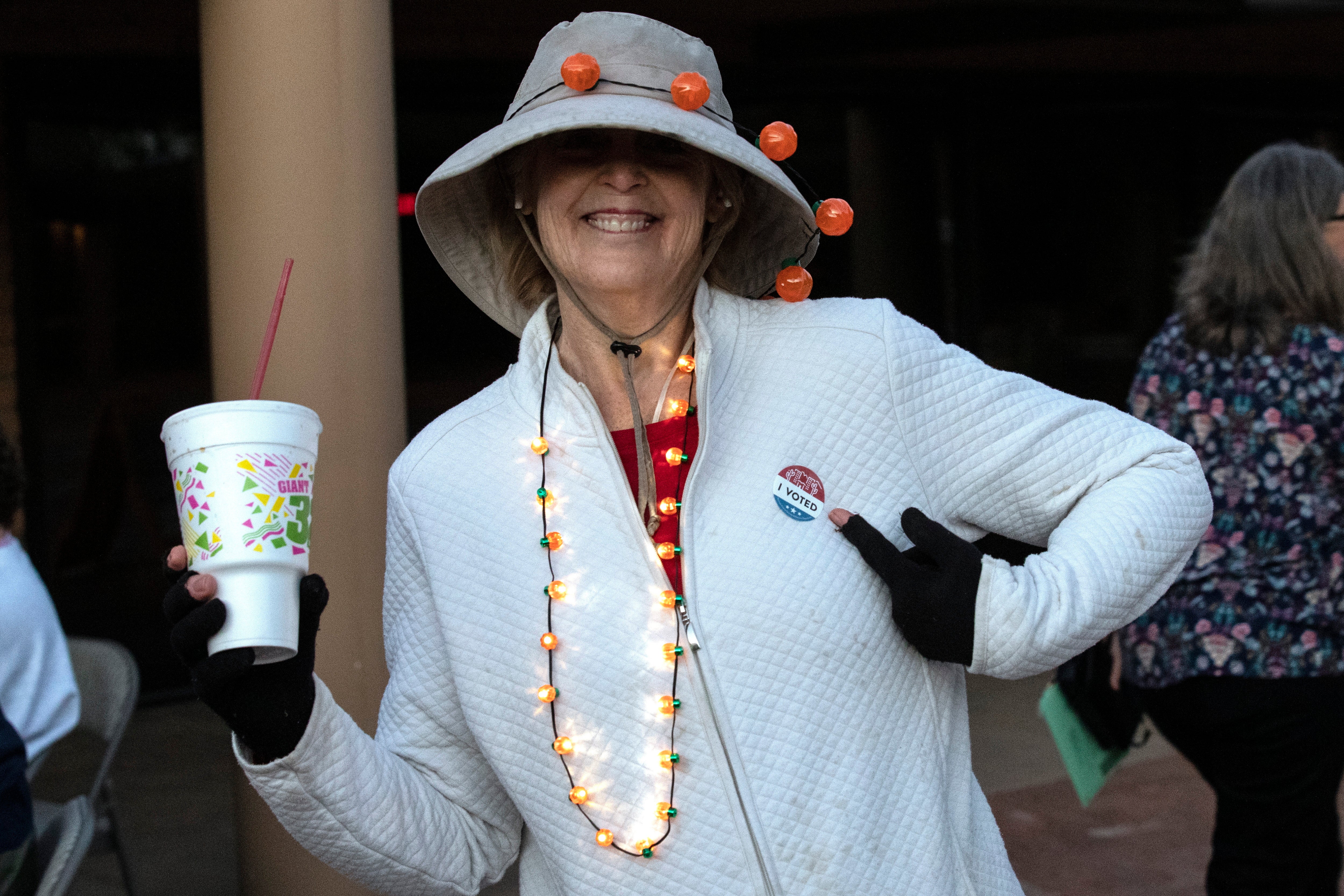 Una ciudadana señala su pegatina de campaña tras emitir su voto iglesia Metodista en Tempe, Arizona.