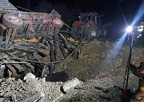 Imagen secundaria 1 - Arriba, policías y forenses recorren los campos del entorno de Przewodow. En las dos imágenes de abajo, el lugar donde cayó el misil