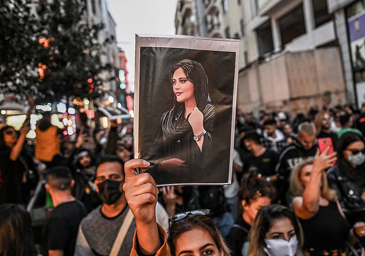 Una mujer sostiene un retrato de Mahsa Amini durante las protestas en Irán