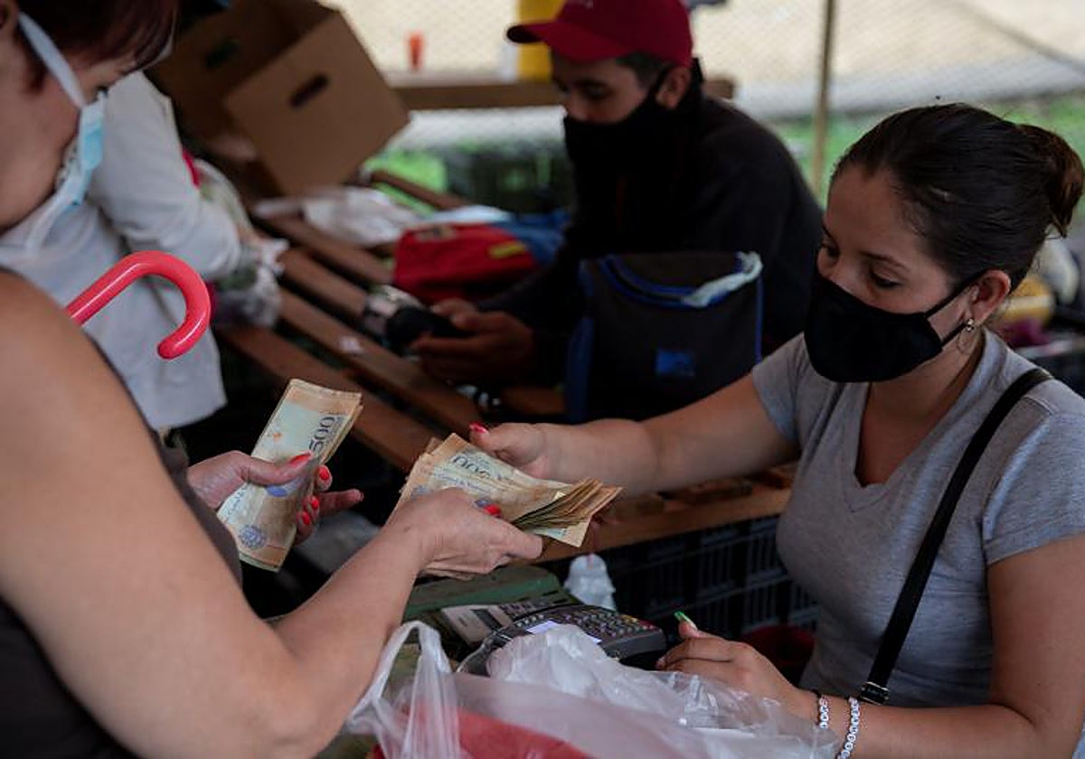 Una mujer paga con bolívares su compra en Caracas