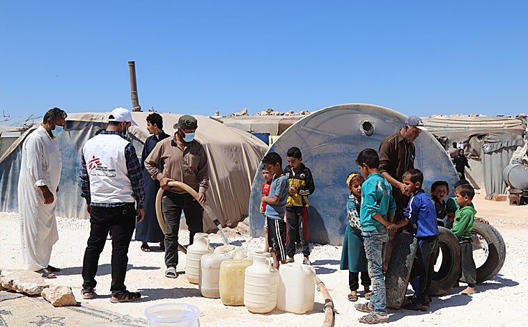 Imagen principal - Arriba, suministro de agua en un campo de desplazados en Siria. Debajo a la izquierda, una trabajadora de Médicos sin Fronteras atiende a niños en Cabo Delgado (Mozambique), a la derecha ataque a un centro sanitario en Tigray (Etiopia), donde han muerto por la violencia 37 trabajadores humanitarios